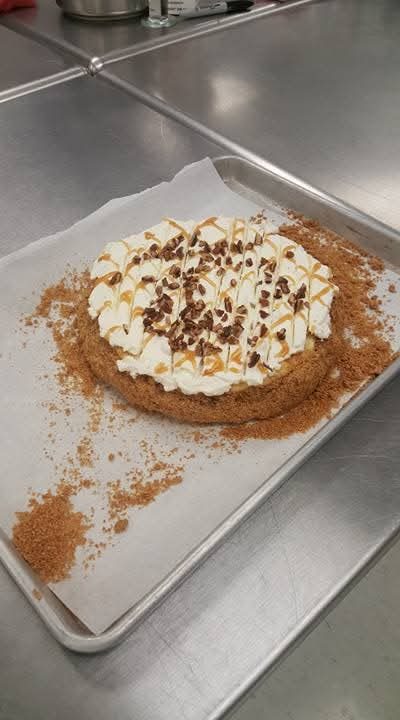 Caramel pecan cheesecake tart with whipped cream and caramel drizzle