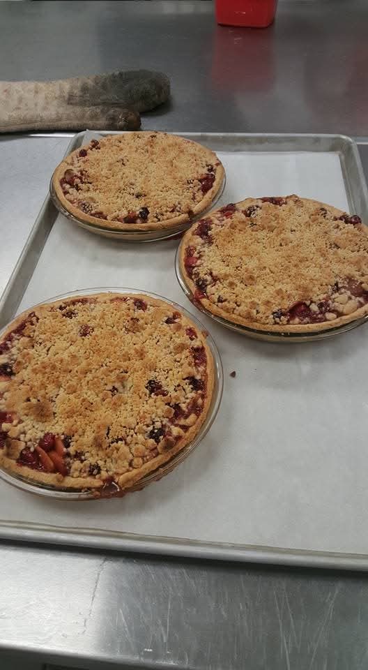 Three individual berry crumble pies fresh from the oven